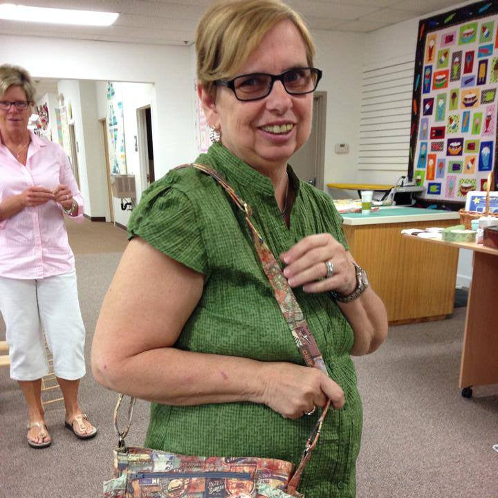 Woman holding a colorful bag in an indoor setting