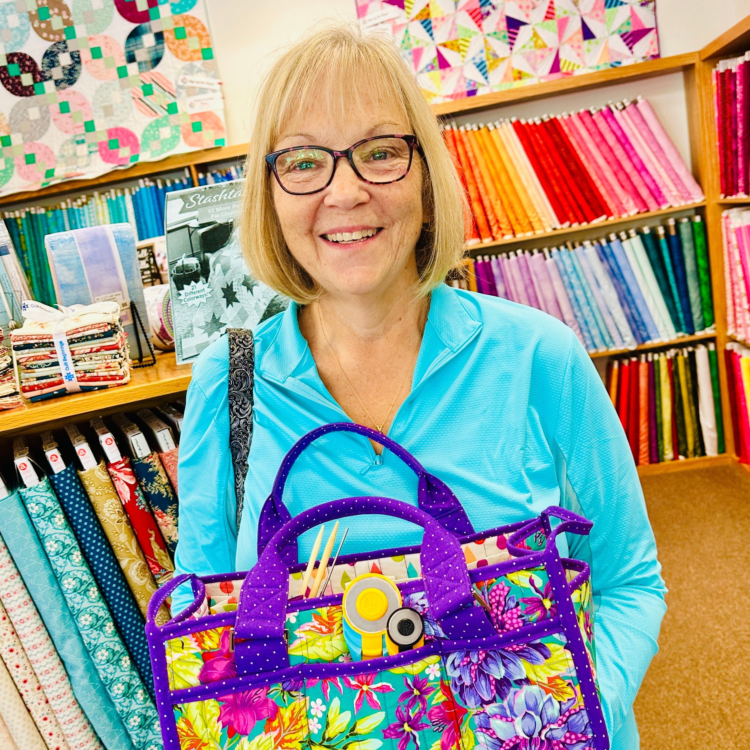 Woman holding a colorful handbag in a fabric store