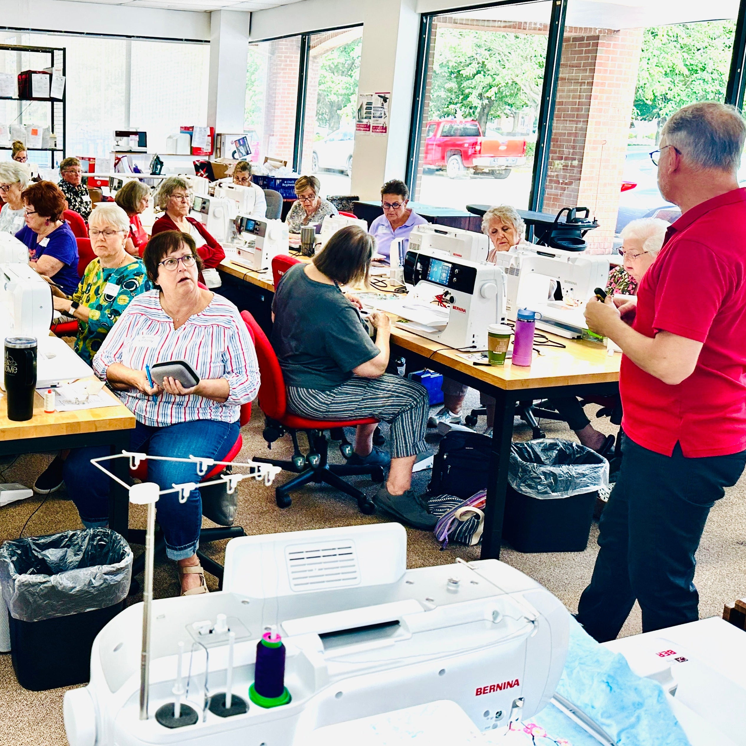 Group of people working on sewing machines in a workshop setting
