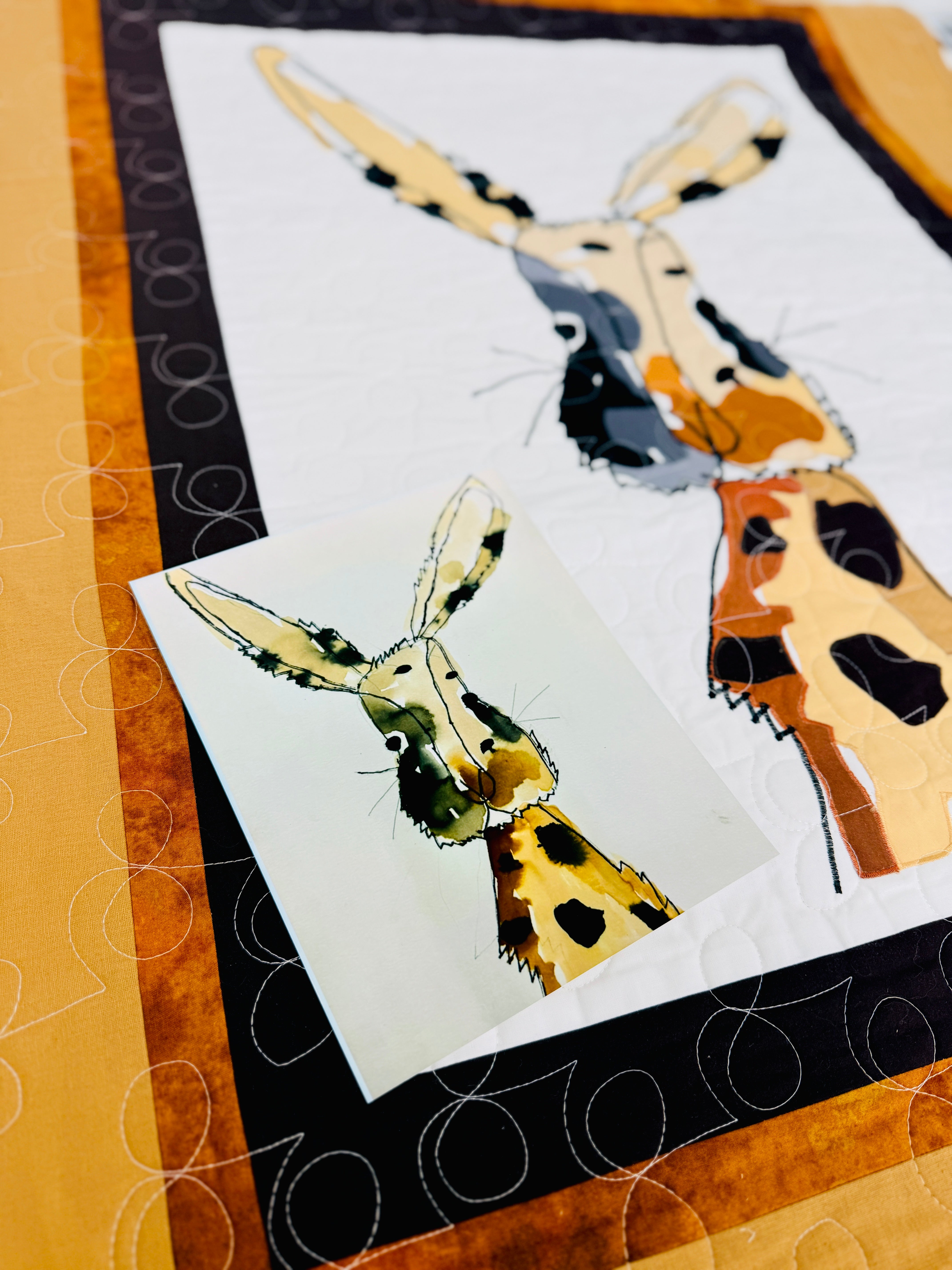 Quilt with appliqué of a deer on a white background