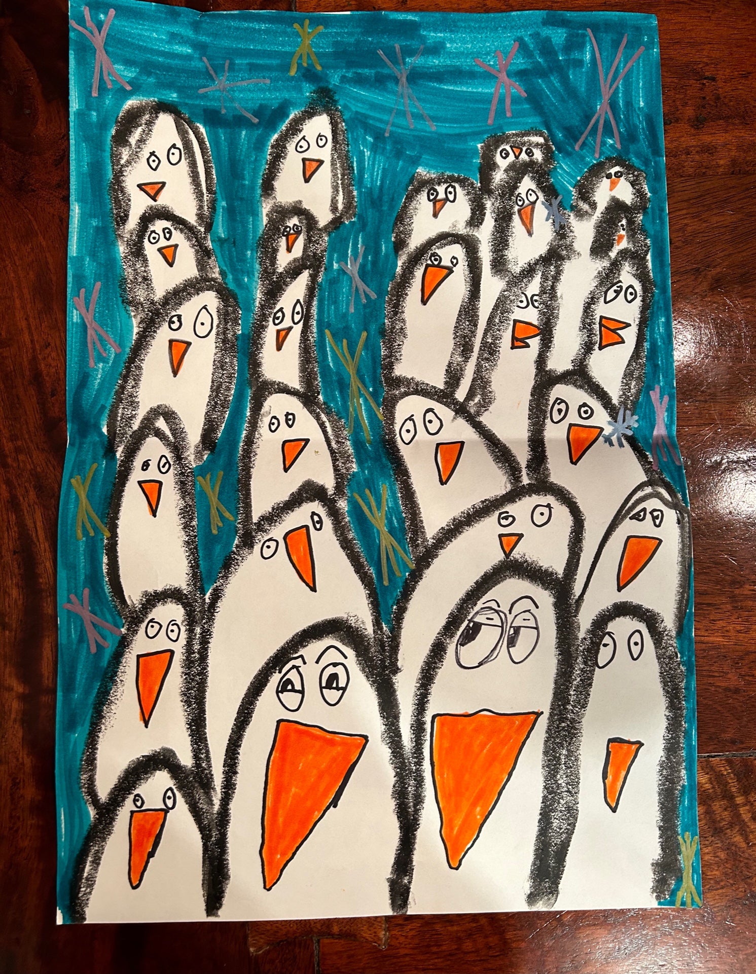 Children's drawing of penguins on a blue and white background