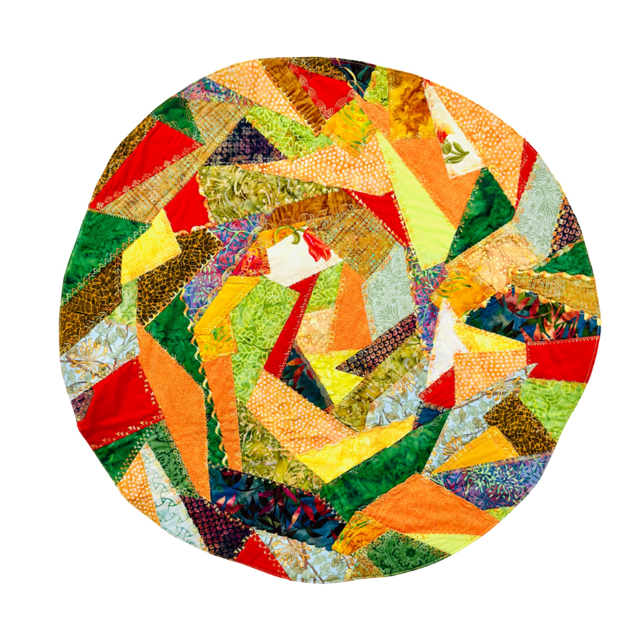 A round patchwork quilt featuring a vibrant, multicolored geometric pattern of various fabric pieces in orange, green, yellow, red, blue, and brown, isolated on a white background.