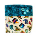 A fabric pouch with a two-tone design. The top flap is dark teal with a spiderweb pattern and three light blue buttons.