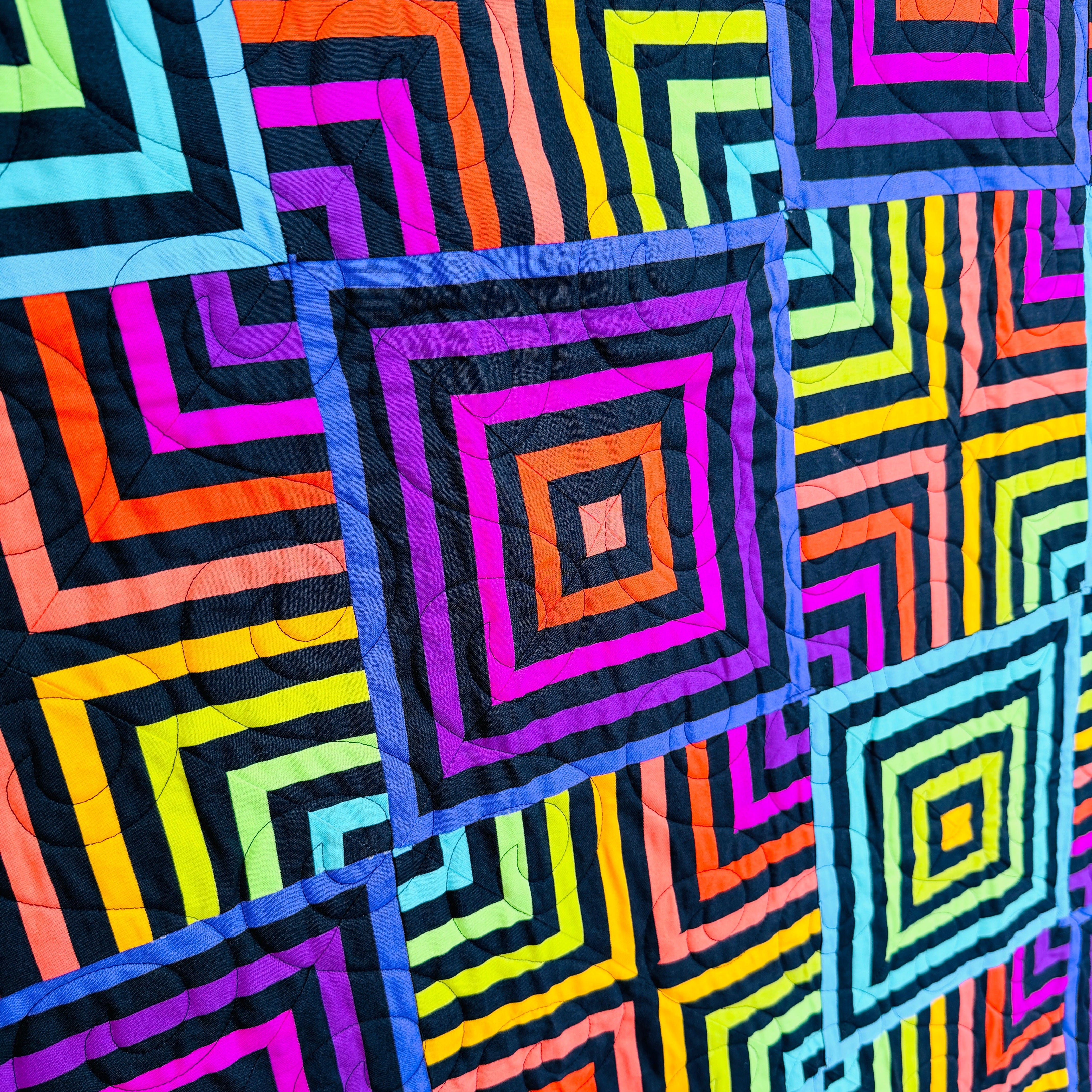 Colorful quilt with geometric pattern on a black background