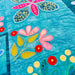 Colorful floral and butterfly design on a quilt with a blue background