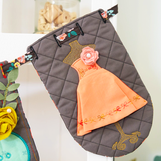 Quilted fabric with embroidered dress design on a white background