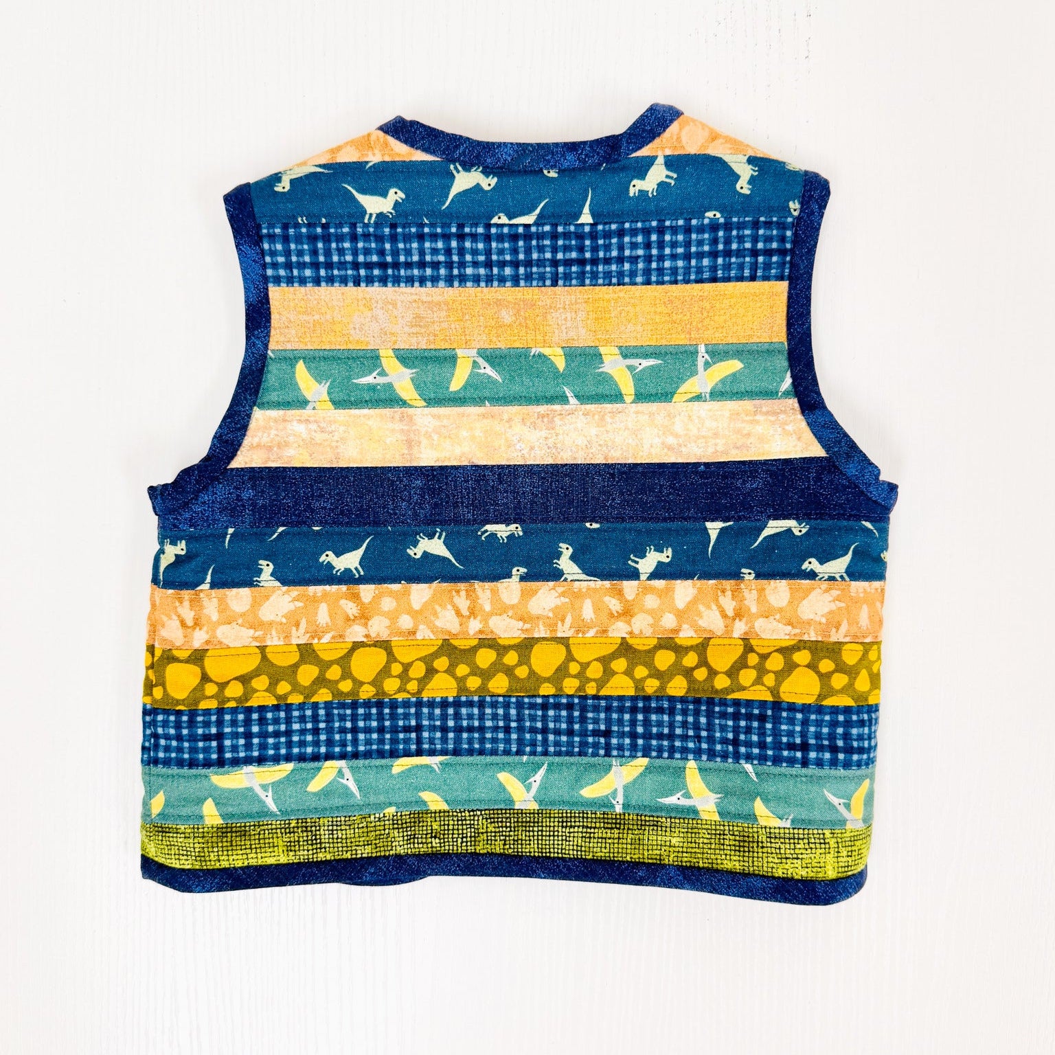 A sleeveless vest with horizontal striped patterns in navy blue, teal, yellow, and orange, featuring small bird motifs and textured stripes, laid flat against a white background.