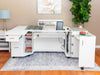 White sewing machine cabinet with open doors in a room with a lamp, plant, and rug.