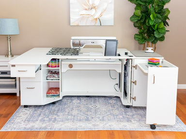 White sewing machine cabinet with open doors in a room with a lamp, plant, and rug.