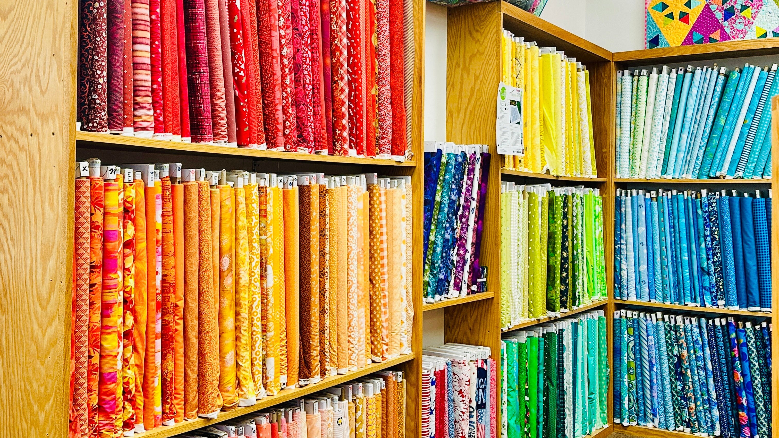 Colorful fabric rolls arranged in a wooden shelf