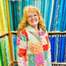 Woman wearing a colorful patchwork jacket in a fabric store