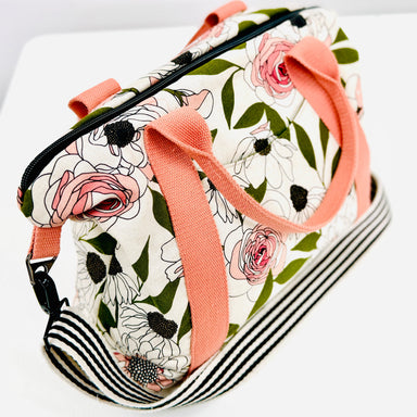 Floral-patterned bag with pink straps on a white background