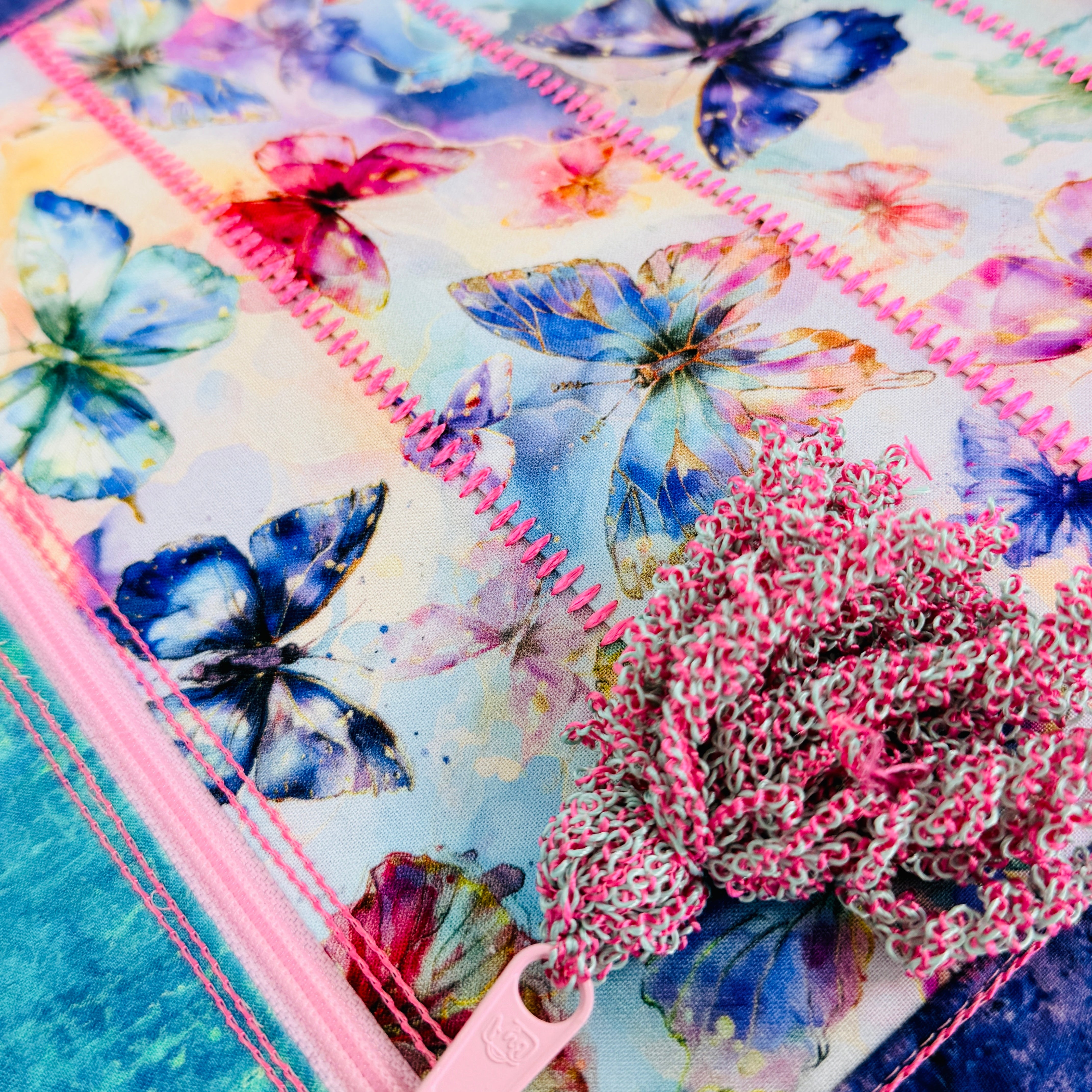 Quilt with butterfly pattern and pink zipper on a blue background