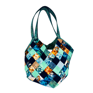 Colorful patchwork handbag with floral patterns on a white background