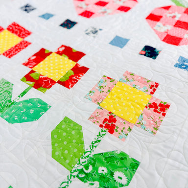Colorful quilt with geometric patterns on a white background