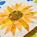 Close-up of a sunflower quilt with colorful fabric pieces.
