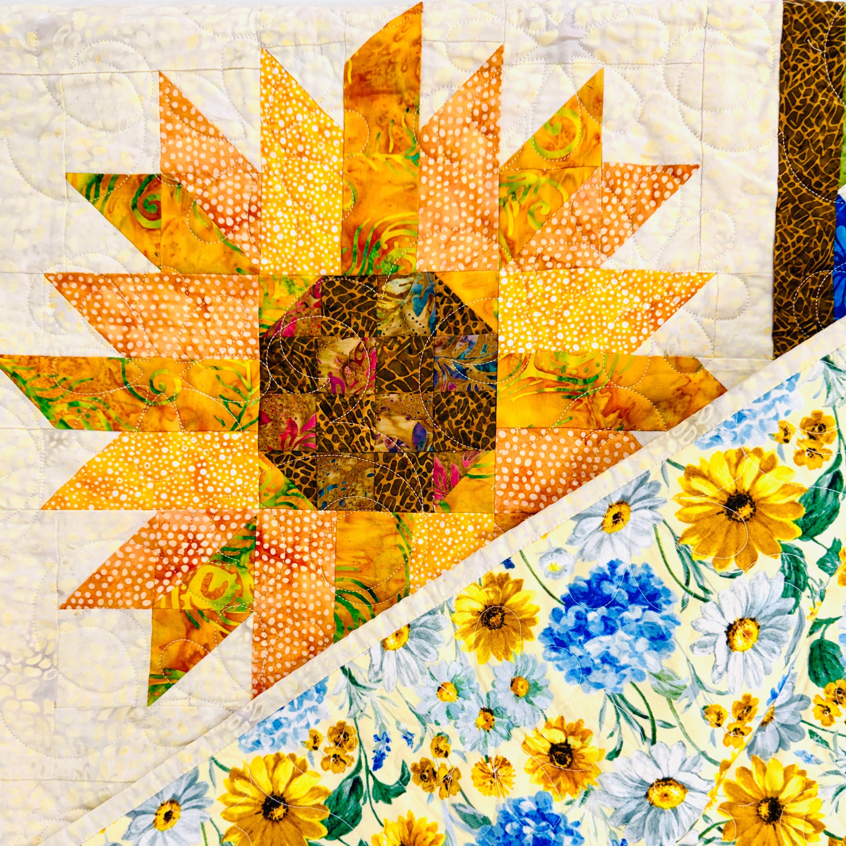 Quilt with sunflower pattern and floral design on a white background