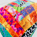 Colorful patchwork quilt with various patterns on a white background