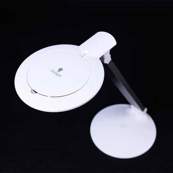White magnifying glass with adjustable arm on a black background