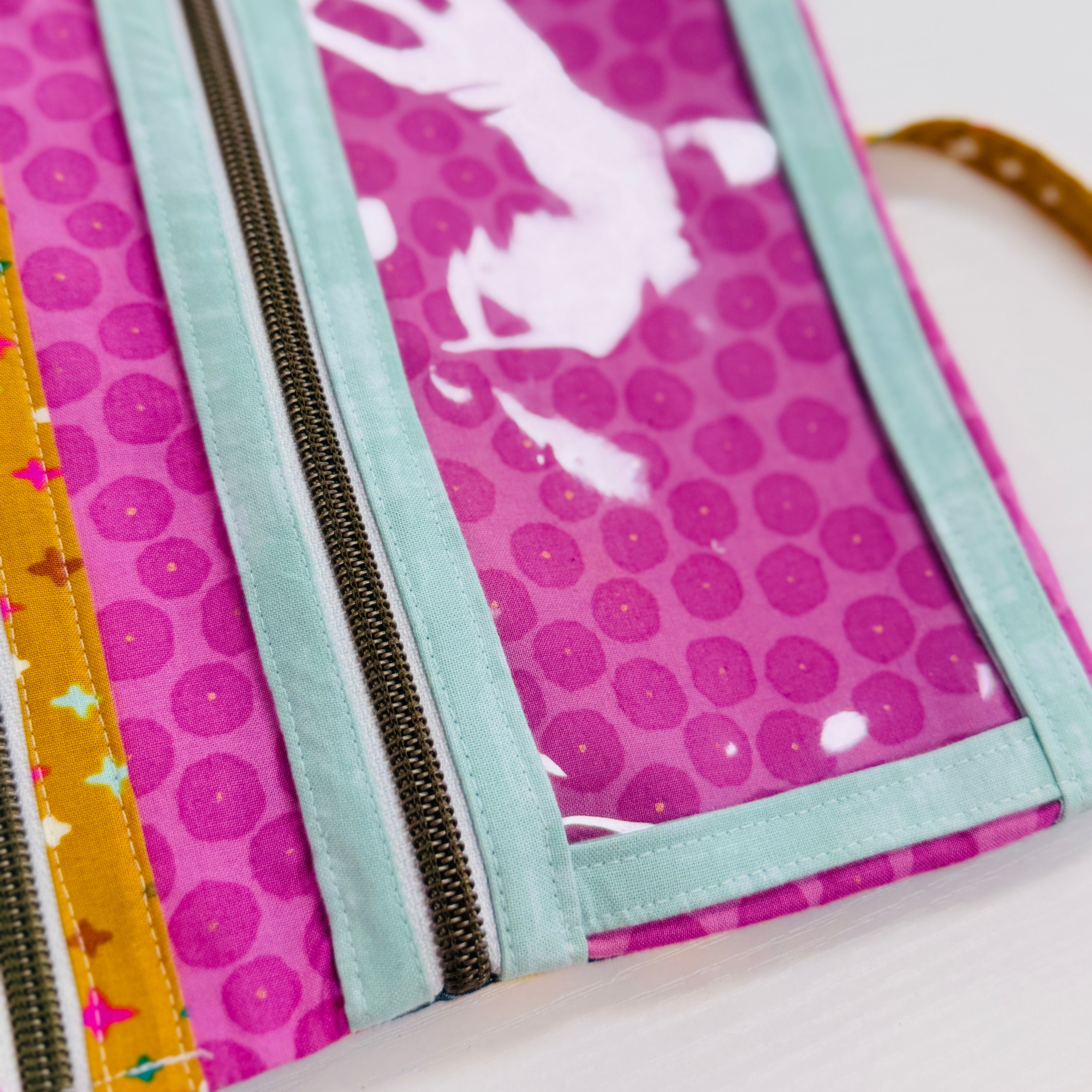 Fabric wallet with zipper and colorful pattern on a white background