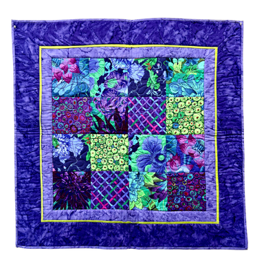 Colorful quilt with floral patterns on a purple background