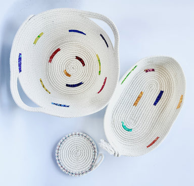 Two rope bowls with multicolored accents on a white background, along with a smaller circular piece of rope craft.