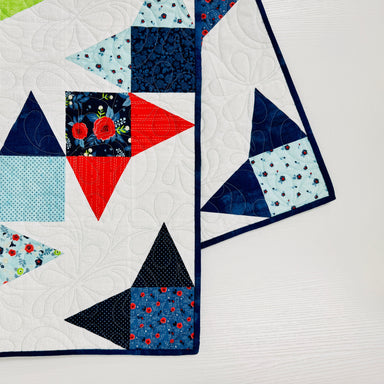 Colorful quilt with geometric patterns on a white background