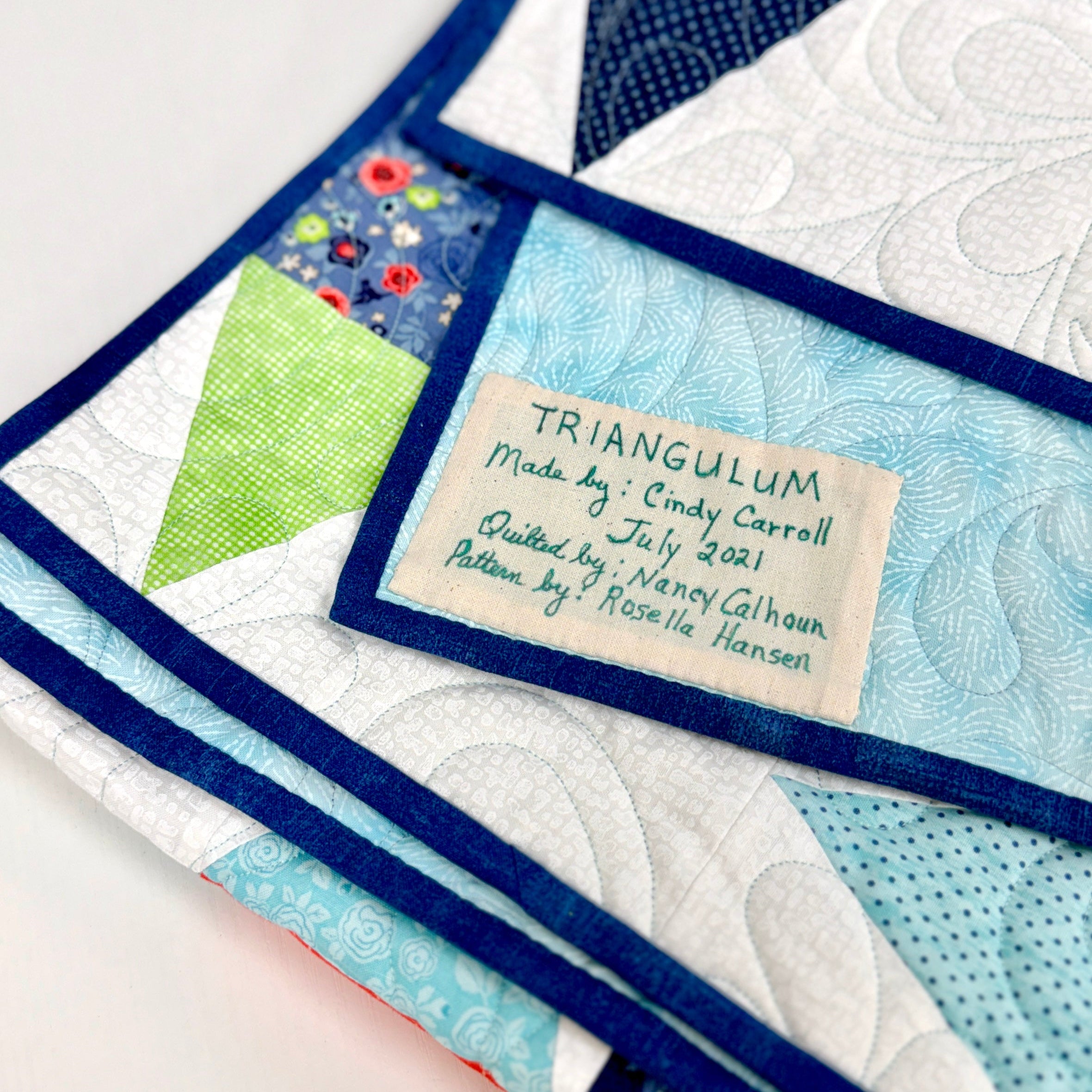 Quilted fabric with a label detailing the maker and date