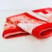 Folded red fabric with white letter 'U' on a light background
