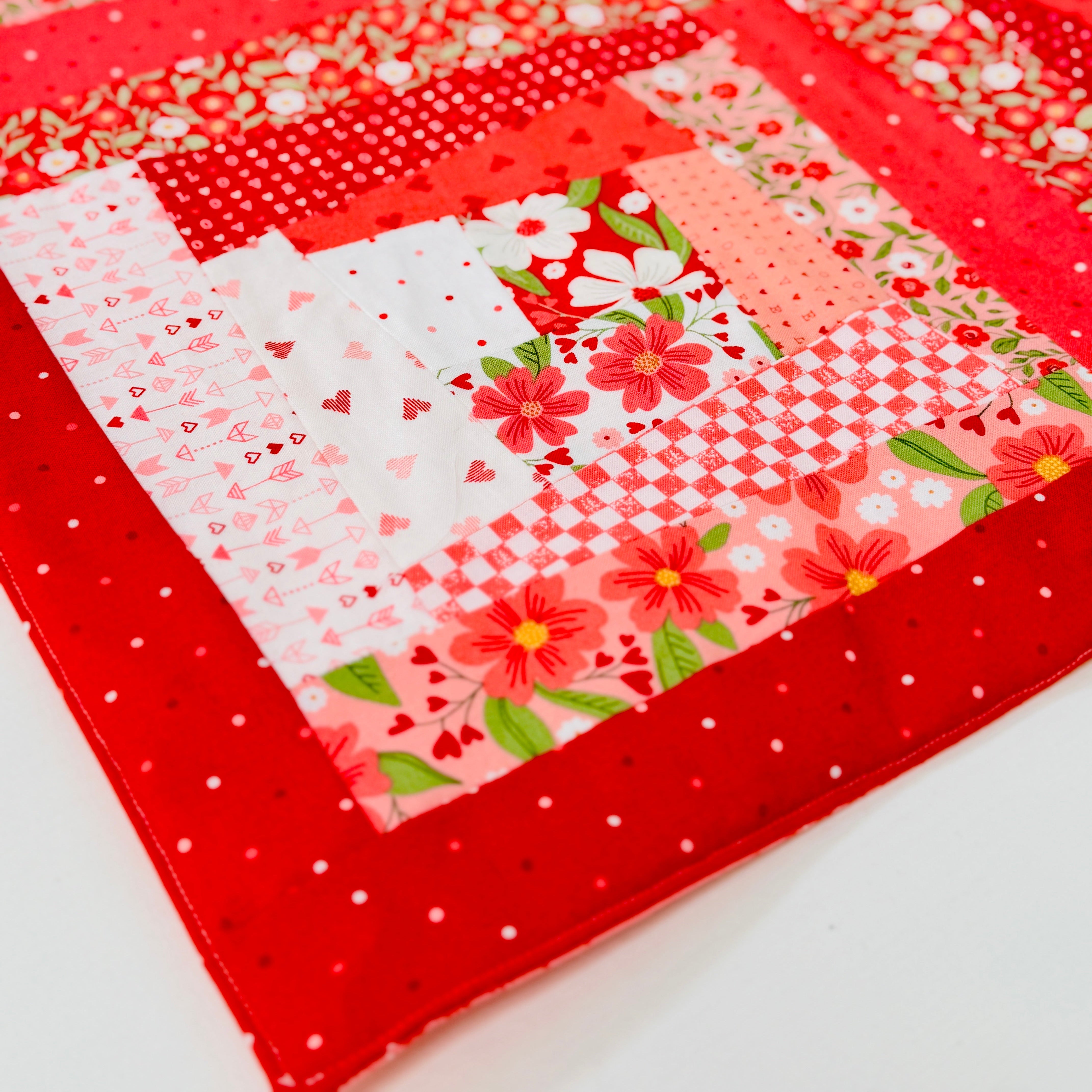 Quilt block with floral patterns on a red background